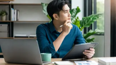 Profesional muda duduk di kantor memikirkan career switch dan transisi karier terukur