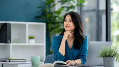 Profesional muda sedang mengelola stres kerja secara sehat di tempat kerja modern